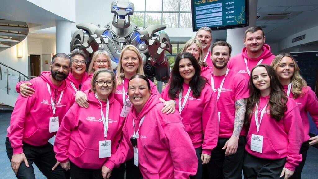 Titan the Robot poses for a photograph with the smiling staff of the Futurescape 2026 event on the Solent.